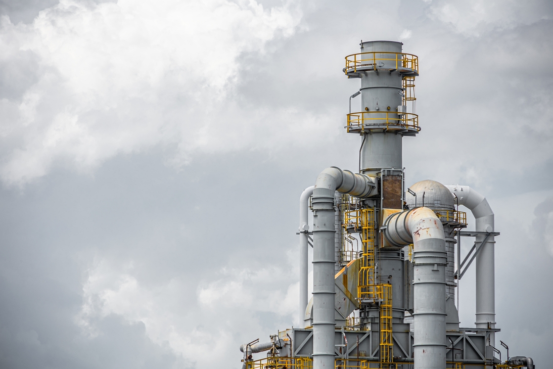 Close-up part of fuel gas pipe complex shown in an oil petroleum refinery plant building distillation columns tower.